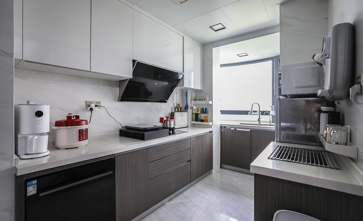 厨房空间很大，U字型三面橱柜，颜色简洁明快，材质要干净和好打理，白色的吊顶和灰色的橱柜相呼应，灰色+白色的橱柜门板。给人干净、清爽、大气华贵的感觉。