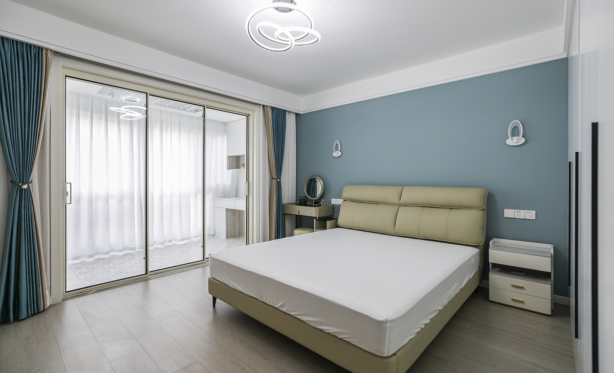 卧室整体采用简约色彩搭配，床头背后一面墙采用深色乳胶漆，有主次分明的界限感，梳妆台代替床头柜的使用功能，节省空间。