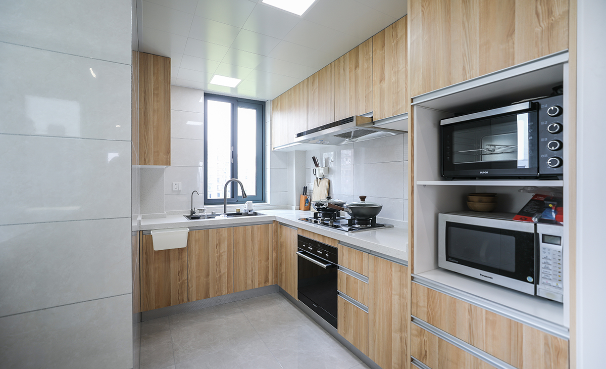 厨房利用了北阳台延伸，增加使用空间，一样采用了原木色系为主打色。和整体风格相呼应。
