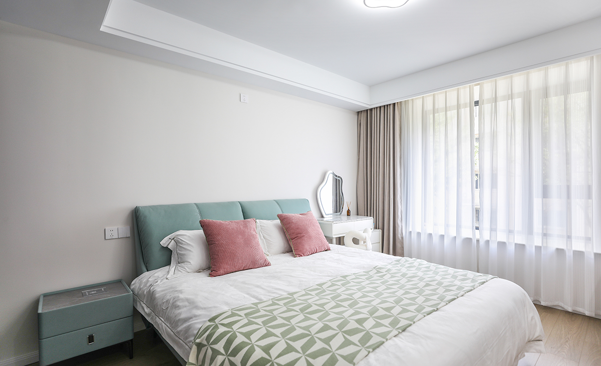 卧室整体采用简约色彩搭配，床头背后一面墙采用浅色乳胶漆，窗帘颜色深一些有主次分明的界限感，梳妆台代替床头柜的使用功能，节省空间。