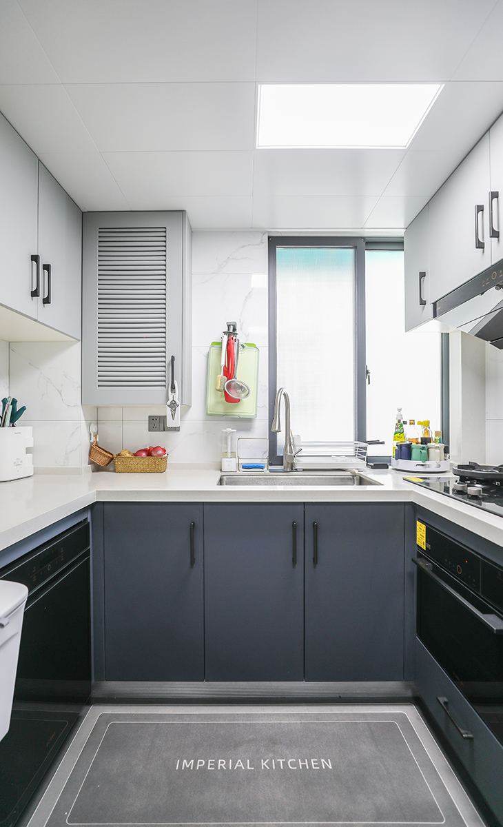 厨房空间一般，设计采用了U型操作台，厨房操作最佳动线之一，颜色搭配上白下灰，简约明朗，材质干净和好打理，石英石台面与上柜颜色遥相呼应，上端的浅色系与下柜的灰色系又形成碰撞，让整个空间轻快许多。