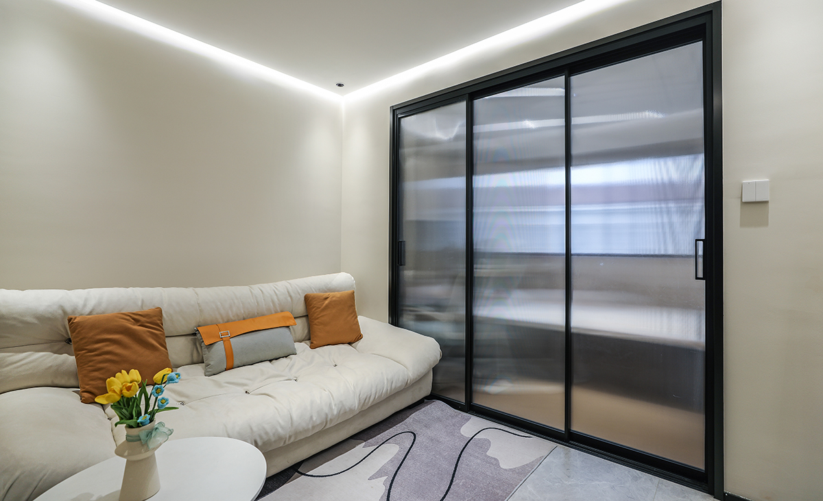 空间整体以米灰色调为主，现代感软装与整体空间色调融为一体，三联动移门更为客厅增加了光亮。