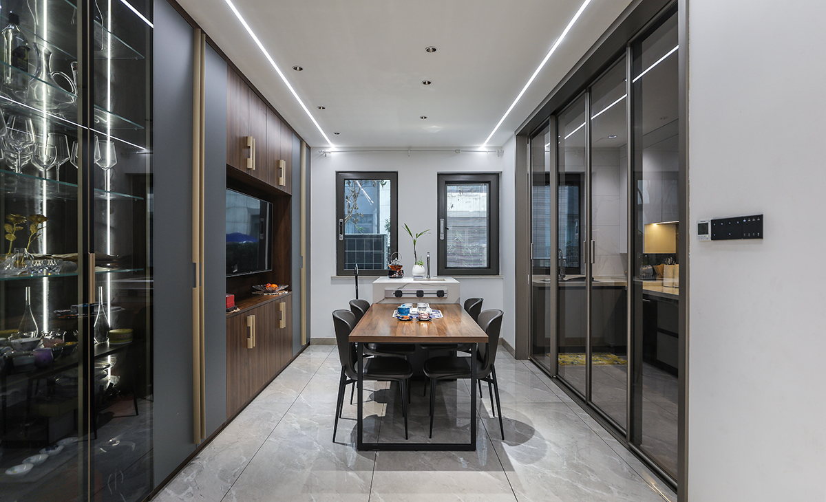 厨房外设立西厨岛台，顶上线性灯，餐边柜用玻璃柜和实体柜门结合，主要还是强调空间感。