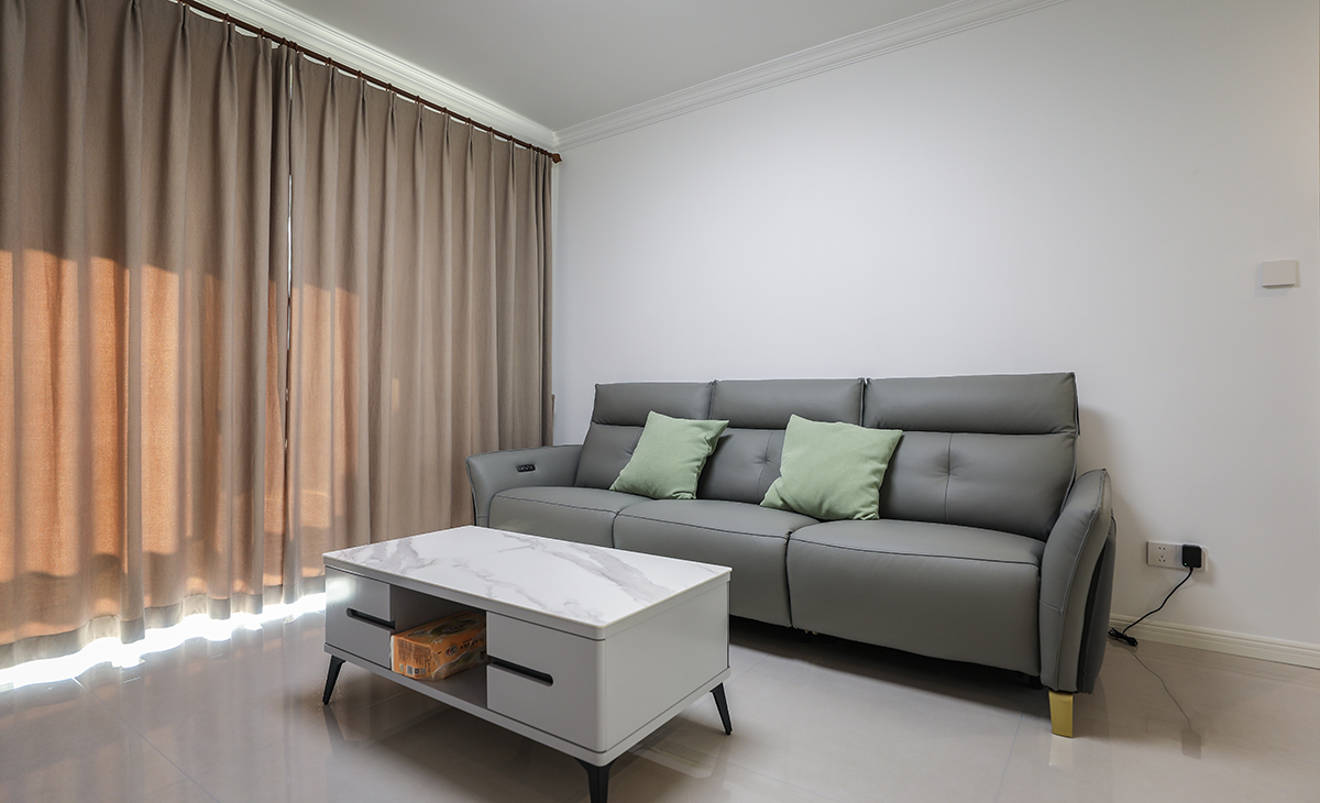 浅灰色沙发+绿色靠垫让客厅的氛围年轻起来了，原木色悬空电视柜，圆弧处理，及实用，又美观，下方便于打理。充满了温馨。