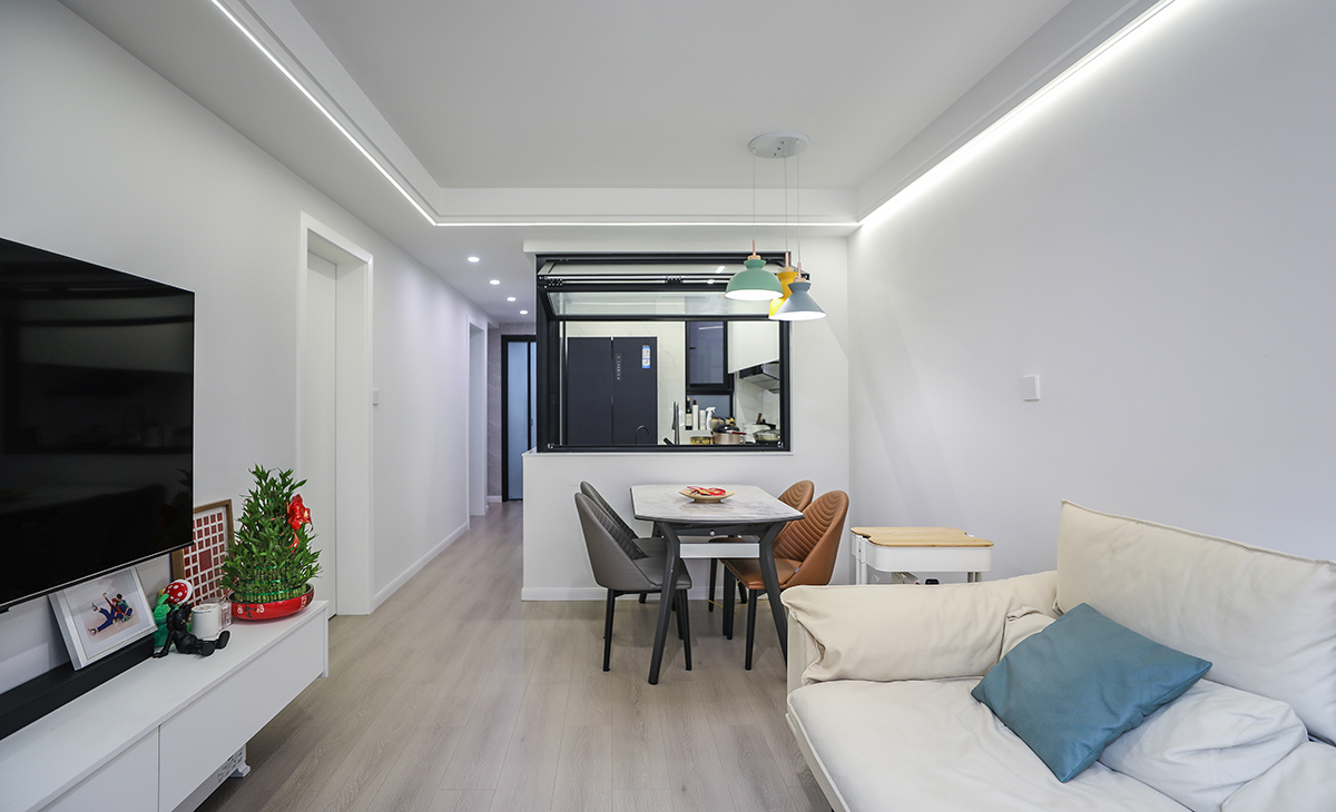 客厅空间整体以米灰色调为主，现代感软装与整体空间色调融为一体，半开放式上翻玻璃隔断增加设计特点，更为客厅增加了光亮。