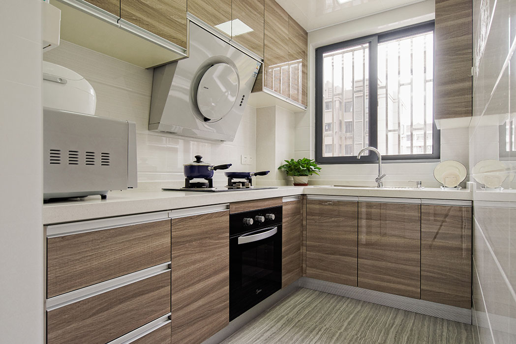 厨房采用灰色系的亚克力系列门板，加上白色的墙面砖，使得空间得以延伸，看上去显得更宽敞