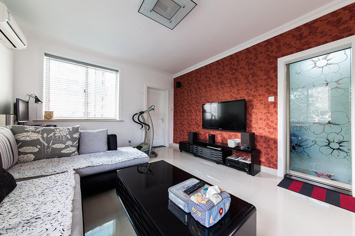 客厅采用淡色系的地砖，运用重色调的沙发、茶几来显现客厅的整体空间，电视背景墙的简单设计使得客厅的这个空间得到点缀，深色墙纸浅色地砖形成一体的视觉拉伸。