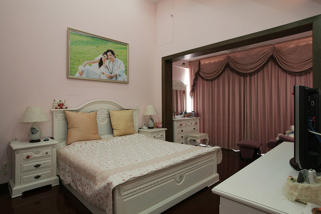 粉色的墙面和白色欧式雕花家具，营造出婚房浪漫、温馨、雅致的氛围。