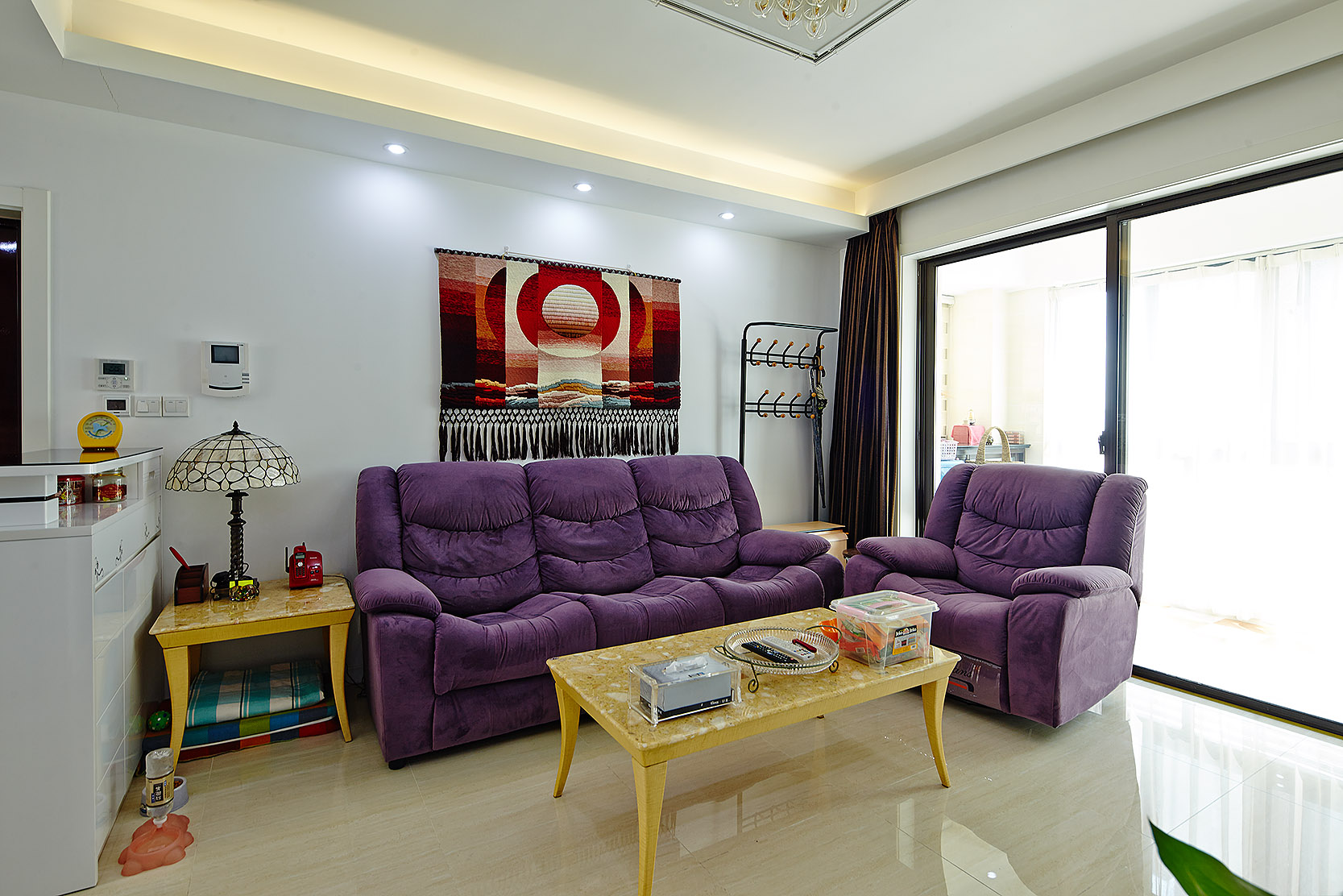 客厅耀眼的紫色沙发，是主人精心挑选的颜色。沙发上更有一副古典的针织挂画，使客厅的空间优雅而气派。
