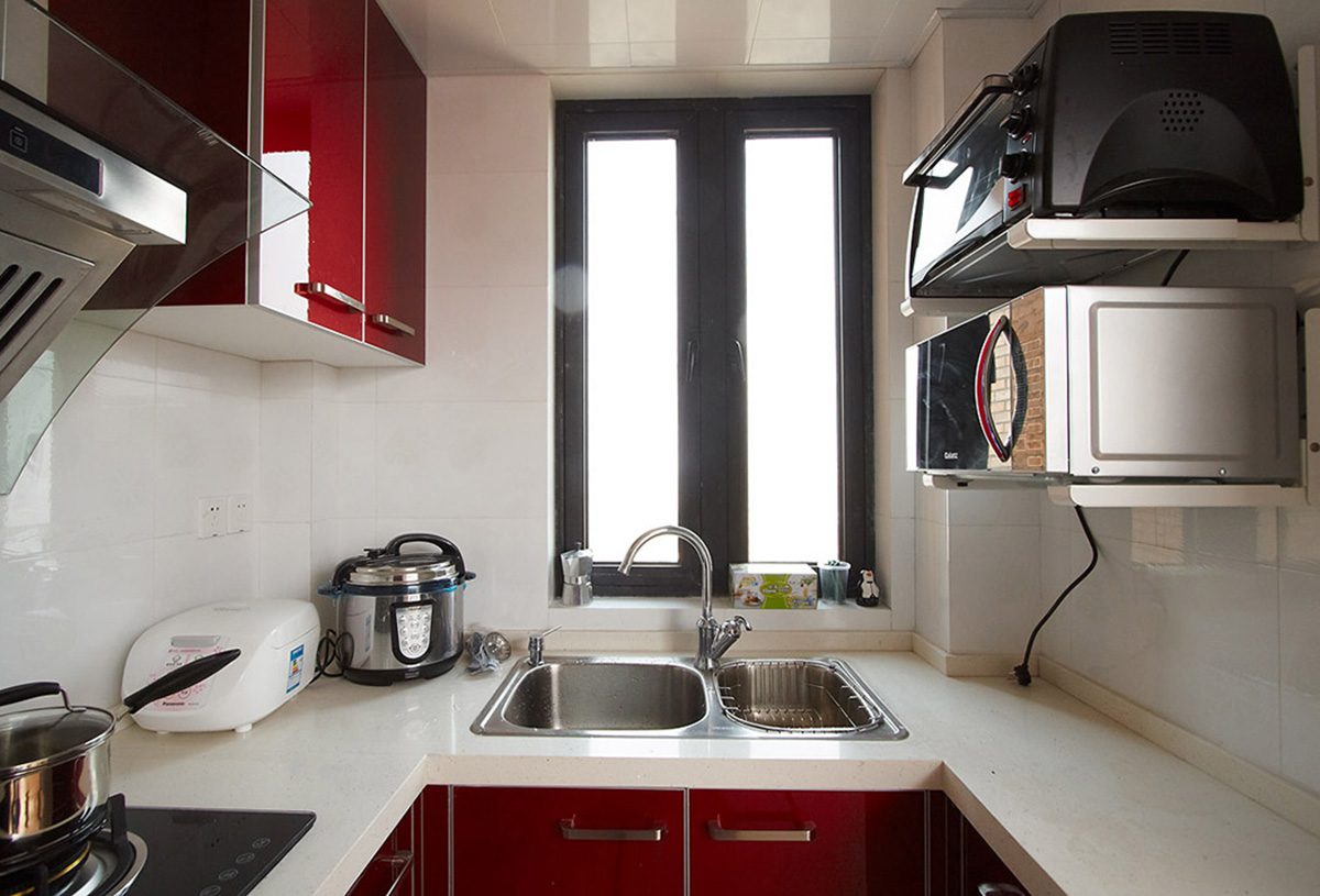 厨房空间小而紧凑，但设计合理，酒红色的橱柜、光亮的材质打理起来也很方便。
