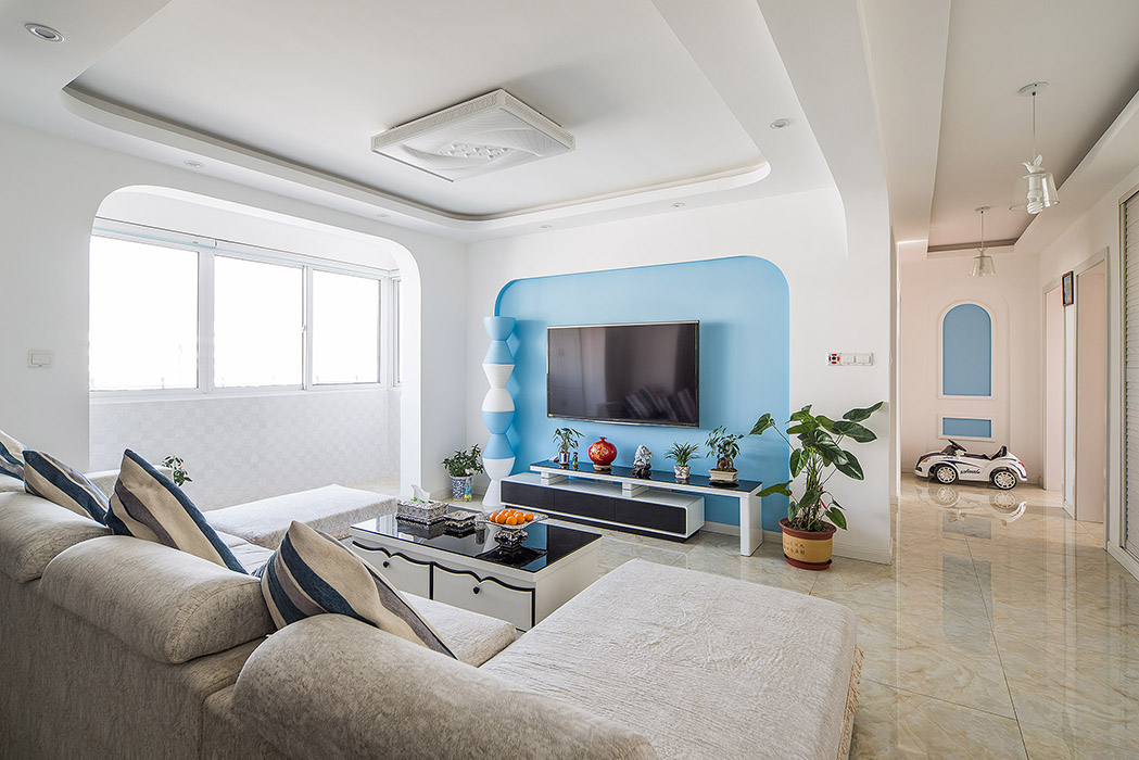 蓝色的背景墙，被白色的墙面衬托的格外醒目，成为客厅的最亮点，弧形的圆角造形，柔和而协调，且增添了几分欧式风情。
