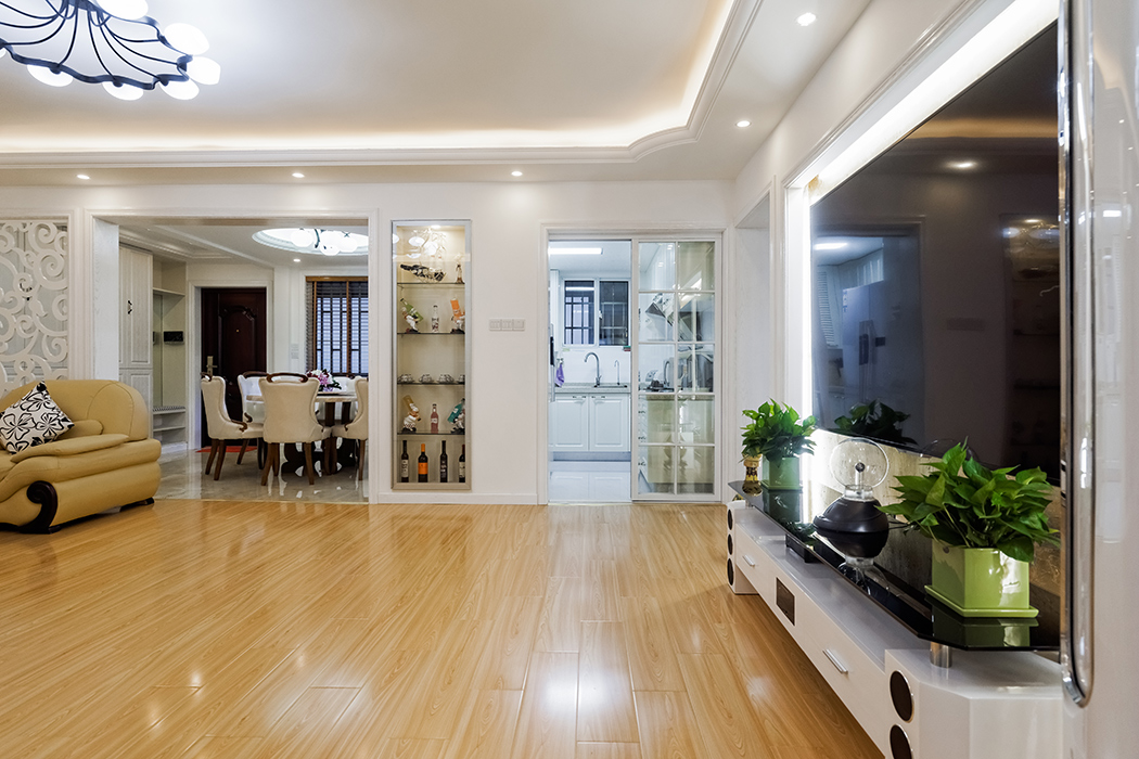 客厅为了配合业主家的米色沙发，地面采用了淡色系的复合地板，家具采用黑白系列，简单干净。没有过多的装饰，通过顶面的弧线设计，让整个客厅显得不那么单调。

