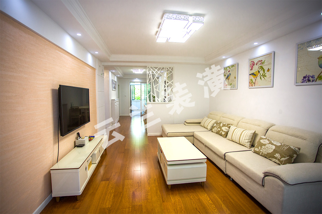 暖色地板、浅色的沙发背景墙和白墙的衬托使整个客厅宽敞明亮，轻暖色调同时也更显文段助于家人之间的沟通。

