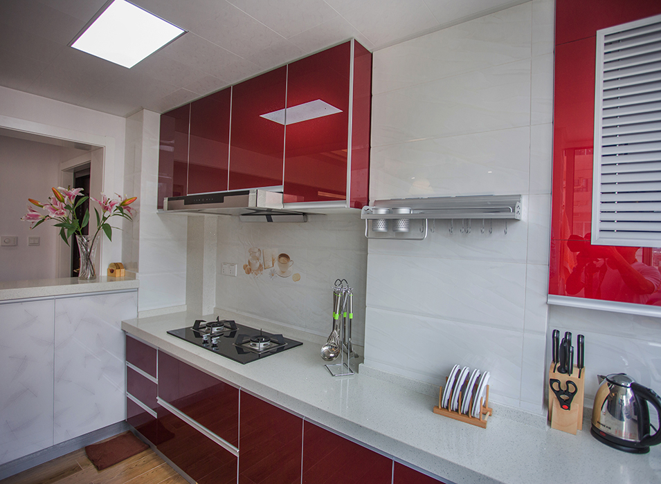 厨房采用红色系的精钢板系列门板，加上白色的墙面砖，使得空间得以延伸，看上去显得更宽敞
