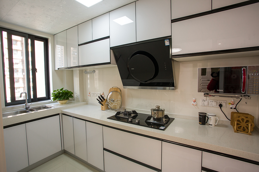 厨房因为空间不大，整体采用白色系，搭配黑色的灶具，凸显空间感。人性化的设计，将水槽处台面抬高，增减了视觉效果及美感。
