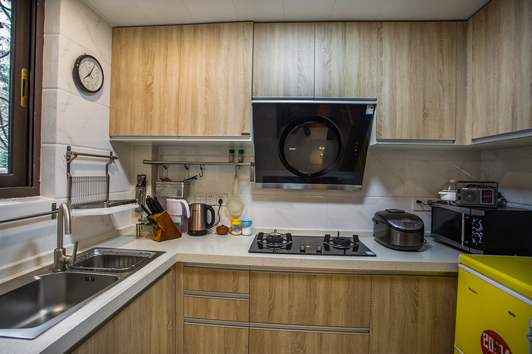 厨房油污较重，因此厨房墙砖和橱柜都是浅色系，整体看起来干净整洁。