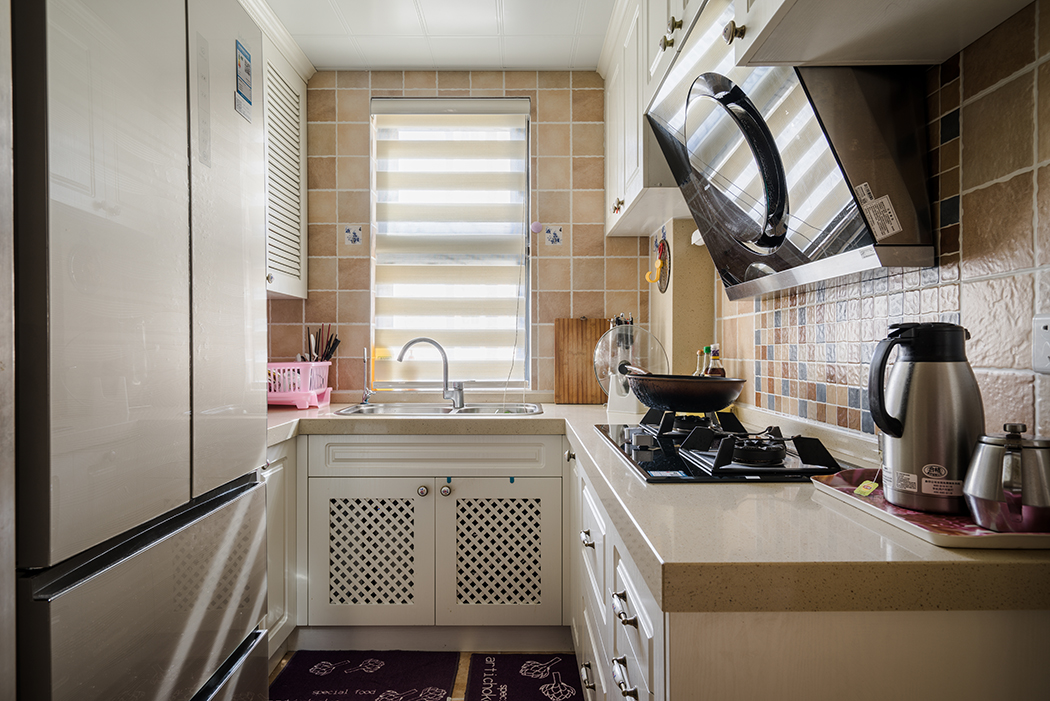 厨房的设计也是本案的一个亮点，简洁的门板造型，配上花格门板的点缀，增添了空间的层次感和立体感，让人做饭的时候有一种愉悦放松的感觉。
