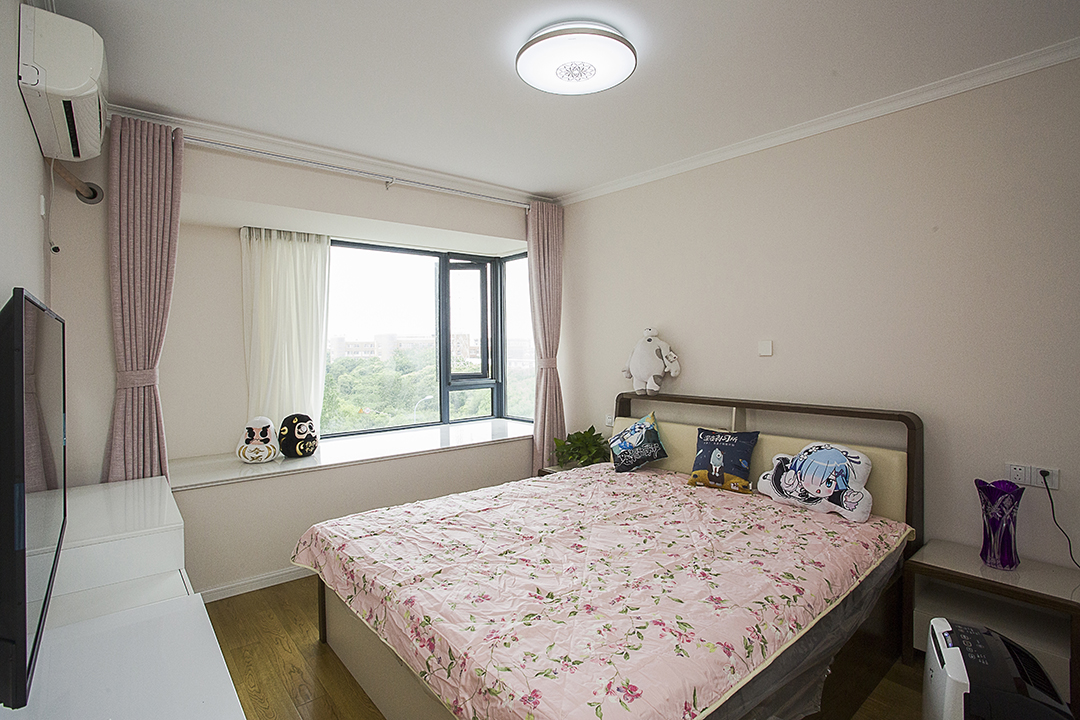 主卧室采用暖色地板和浅色衣柜搭配，整个房间以粉色为主体，将粉色的应用发挥的淋淋尽致，伴有简欧风格。飘窗的简单，展现软饰的搭配，体现两位新人心心相印。
