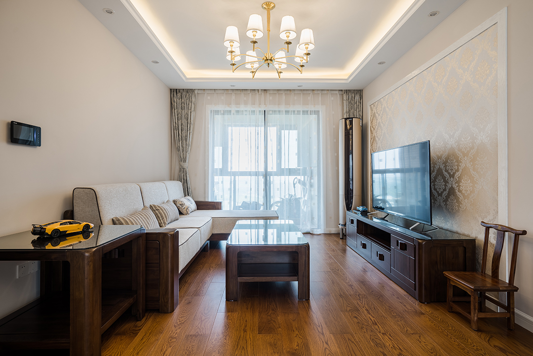 客厅实木地板和实木家具让一切回到最初的纯粹，米黄色的墙面搭以同色系的沙发，稍加点缀的窗帘，整个空间通畅自然。
