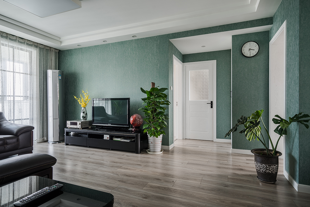 客厅的墙面采用了深绿色壁纸，给墙面增加了不一样的色彩
