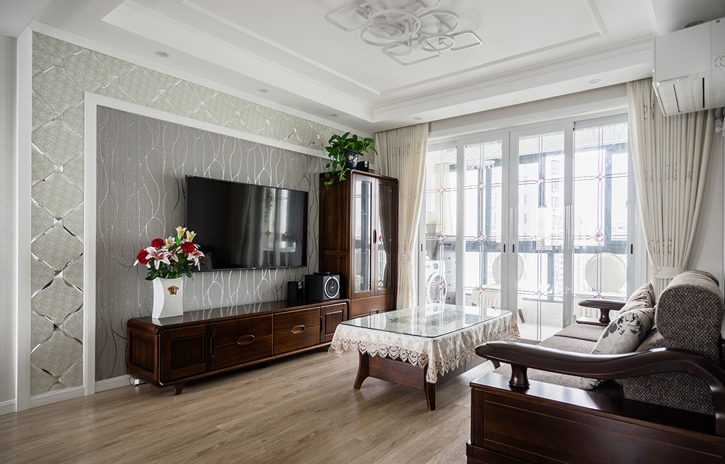 客厅简洁的线条与米色的墙面，地面凝结成暖调，营造了一片温馨；实木家具与墙面以强烈的色彩，陈设出家的自在和品质。
