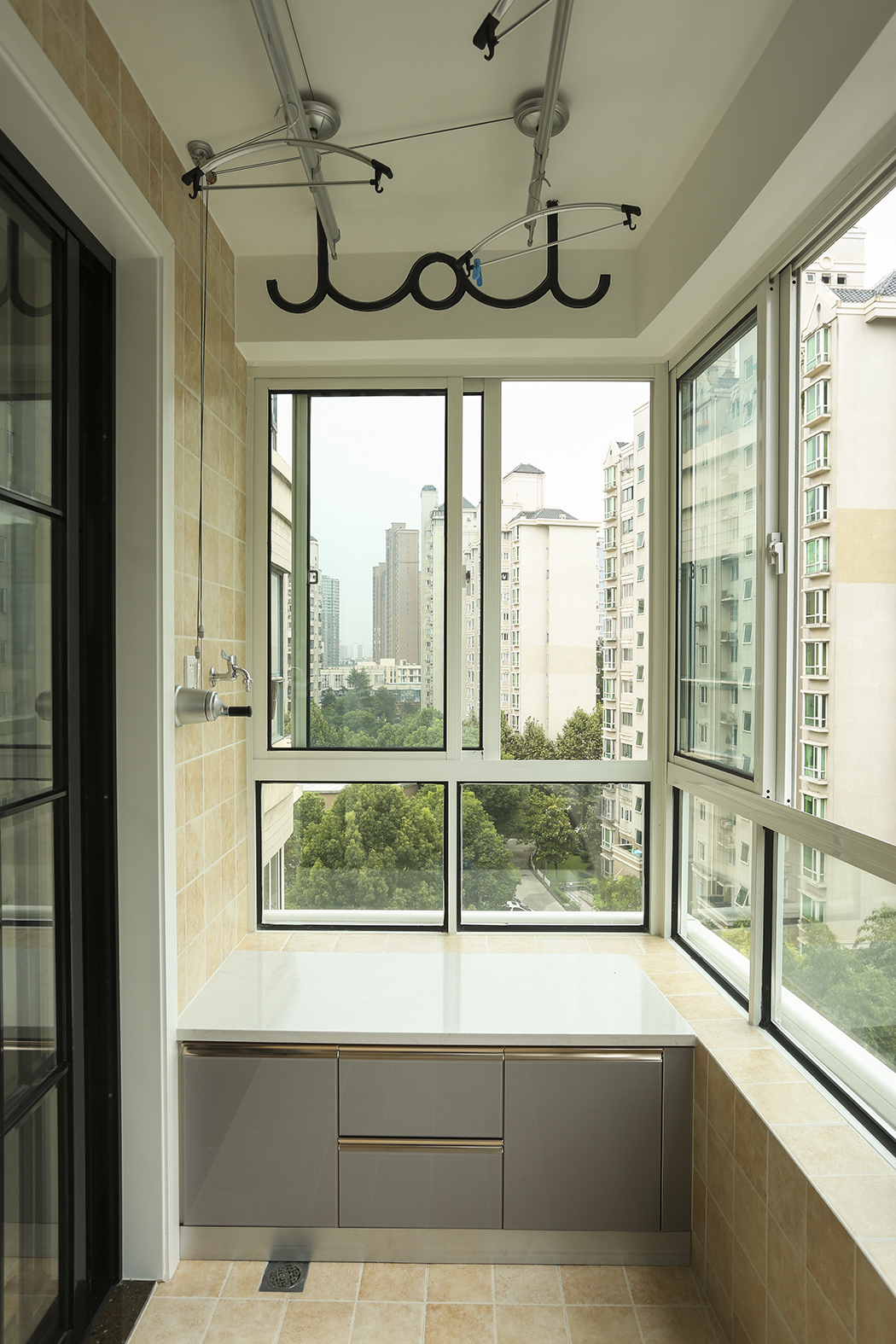 阳台的瓷砖选择了仿古亚光面的感觉，让阳台成为了一个休闲工作的空间，定制的洗衣机一体柜让空间摆放更加的合情合理。
