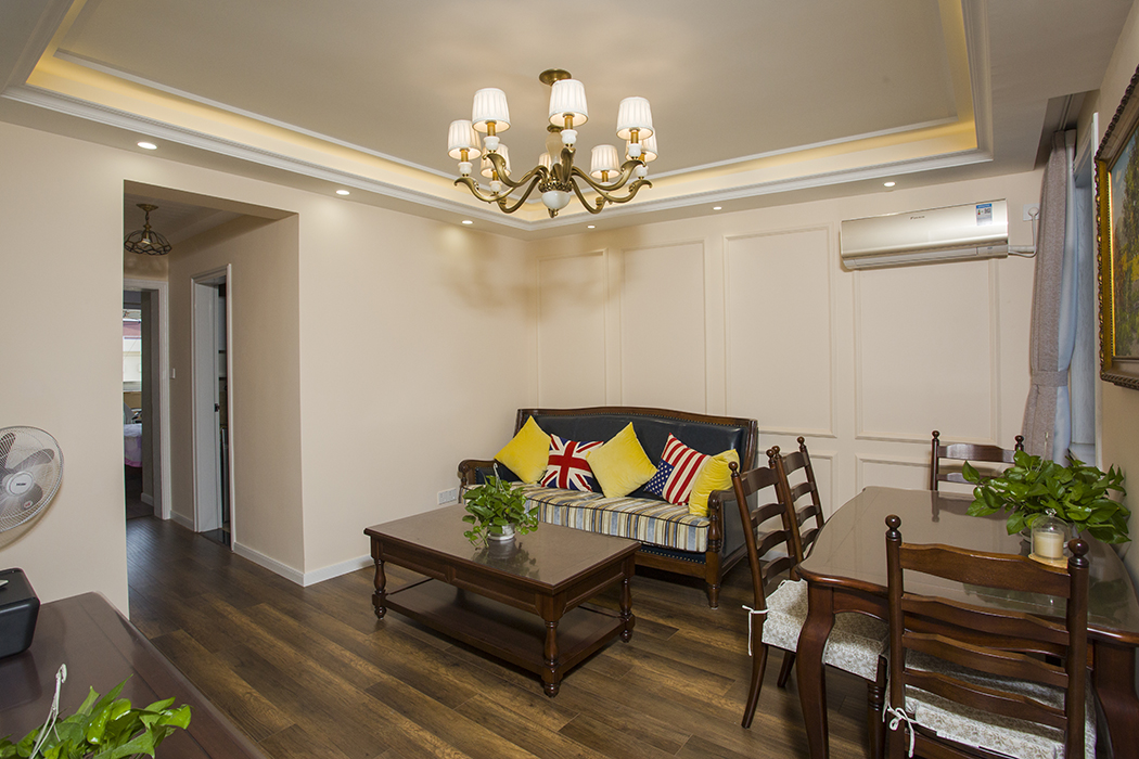 客厅整体风格采用暖色涂料和深色的地板合理搭配，沙发背景墙采用以线条为基础的设计，使得整体空间的延伸，吊顶采用简单线条，以中性色的灯带，使得光线得以补充。
