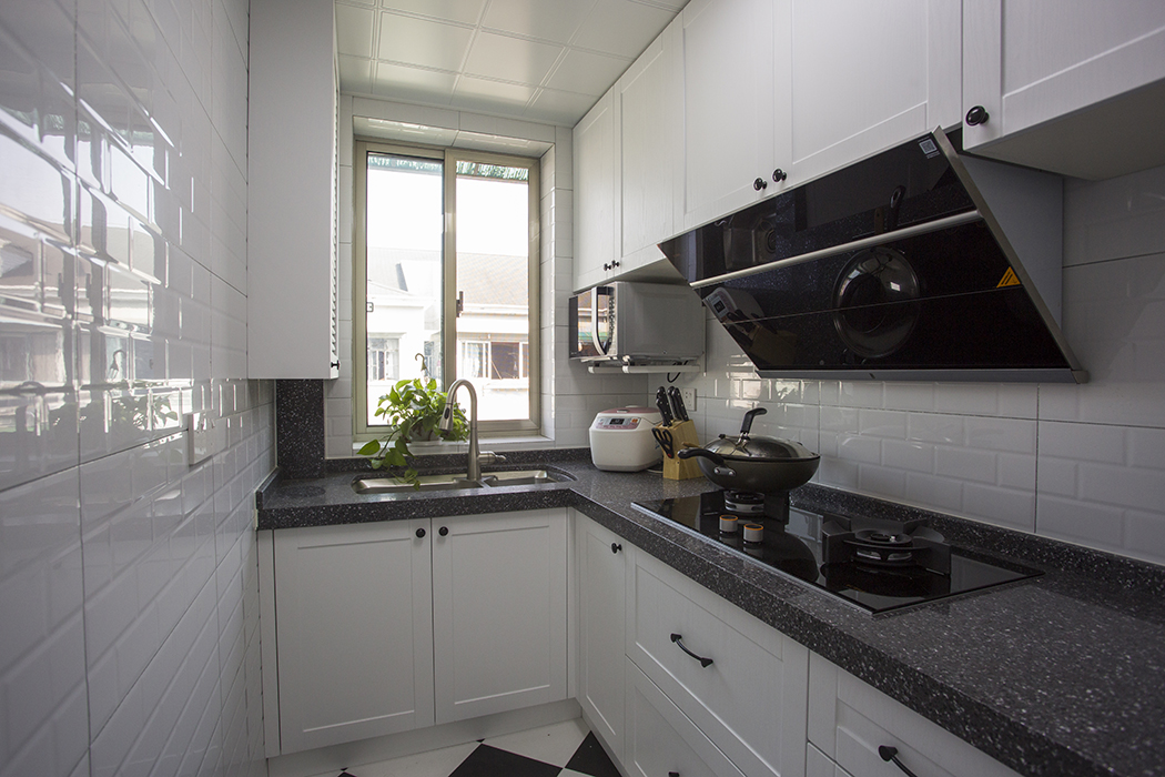 厨房采用白色色系，充分体现简约风格，侧吸的烟机，黑色台面的搭配，显现出客户的细腻生活，黑色和白色的搭配更加的合理大气，充分释放小户型的空间。
