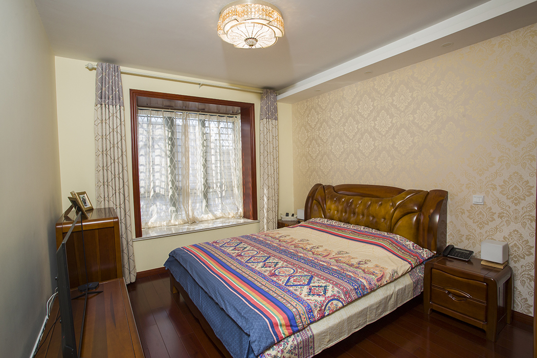 卧室主要还是按照中式家具来搭配，没有过多花式的搭配，只有床背后的欧式墙纸和欧式的吸顶吊灯，随处都彰显欧式和中式的元素。
