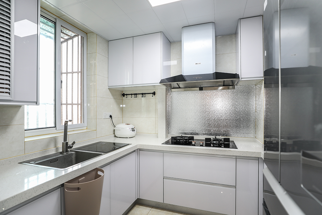 厨房白色的门板搭配淡色的台面，干净清爽。水槽洗碗机的配置，解放双手的同时，又增加了功能性。
