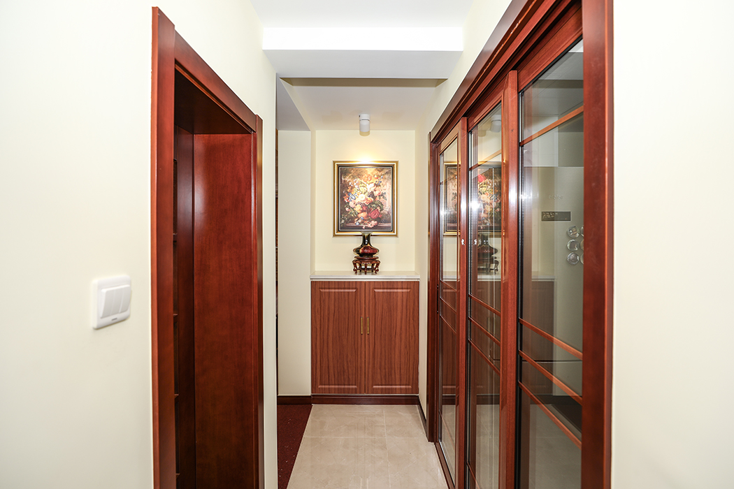 玄关的壁画，灯光，作为高端的背景材料增加了整体的档次，红木色的门套及门板反应出家居的奢华低调。