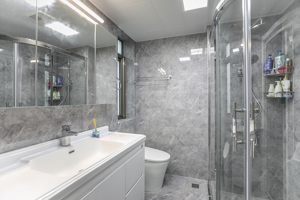 大格局的卫生间墙地面选择了近几年最受欢迎的灰色瓷砖，和白色的卫浴洁具台盆柜有了一个明显的对比色。