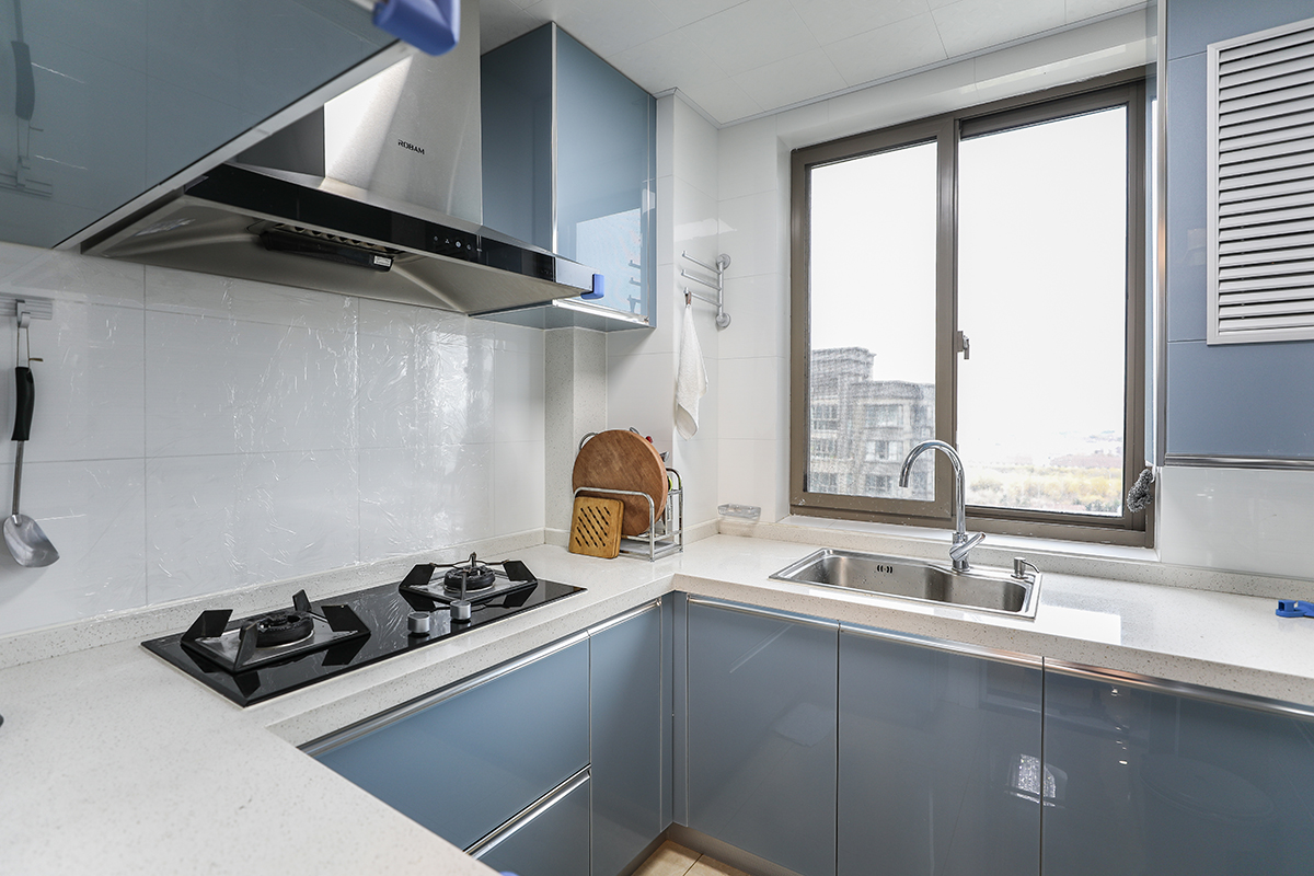 为了更好的利用空间，已经更方便日常使用，厨房橱柜做成U字形，白色的墙砖和蓝色橱柜门板，大气明亮。
