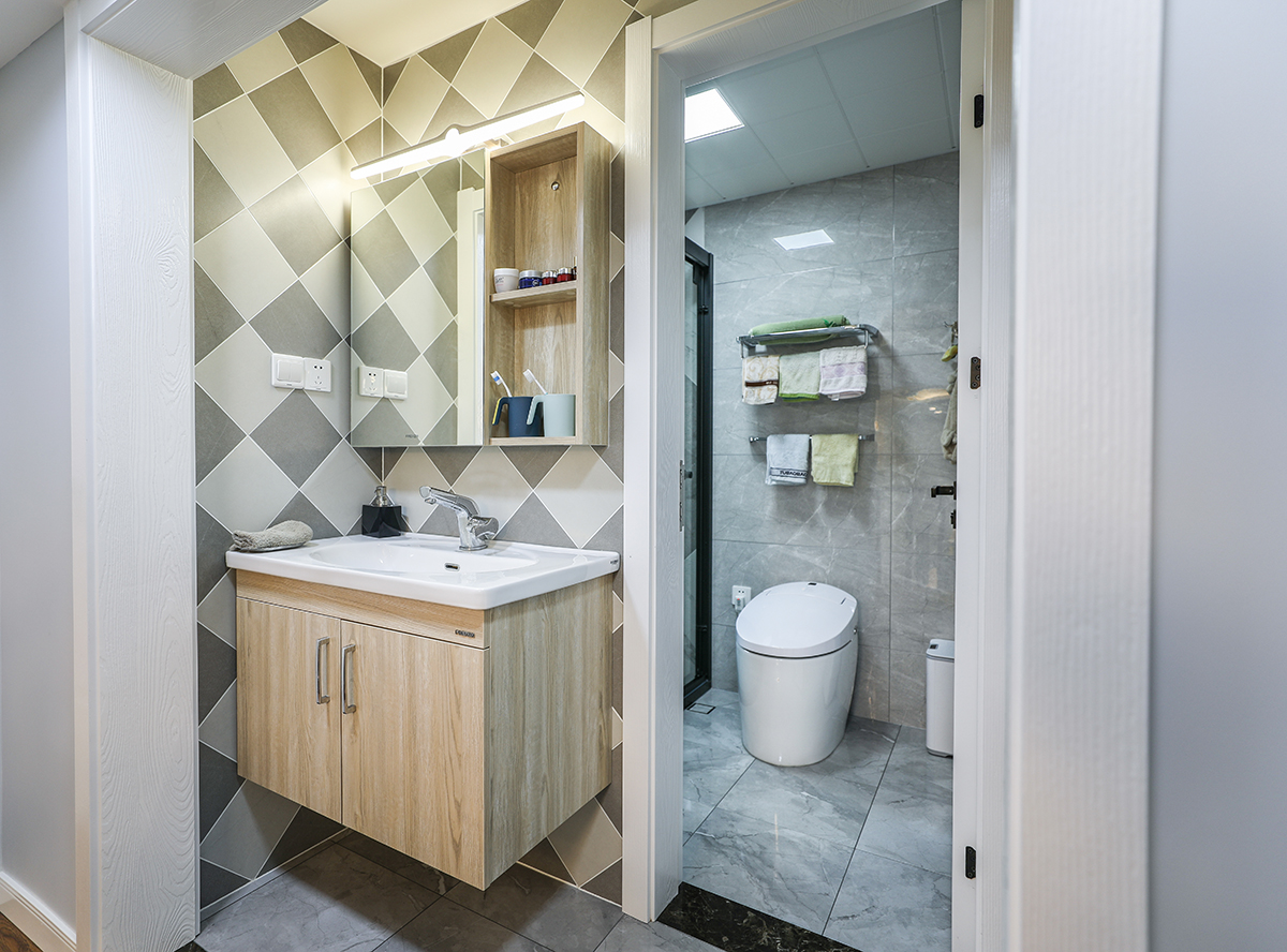 卫生间的设采用当下流行的黑白灰的现代风，淋浴房背景的墙砖拼花，黑色的淋浴房移门，让黑白灰完美的结合在一起，干区的木纹太闷和墙面的拼花砖，=使干区更加的吸引眼球。
