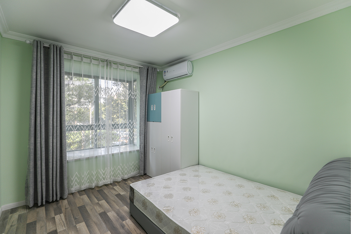 次卧室为儿童房采用绿色系为主的色彩搭配，整个房间以浅蓝色为主体，加上木纹和白色门板的家具的搭配，使得整体色调非常的协调，飘窗的设计在极小的空间使得活动空间的整体释放。
