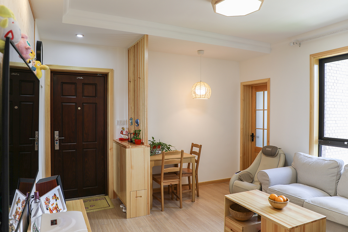 客厅整体风格采用日式原木风格，门厅做简单的原木玄关把餐厅和客厅做一个分割，划分独立的区域。客抽拉的换鞋凳，无处不在的也体现出细节。
