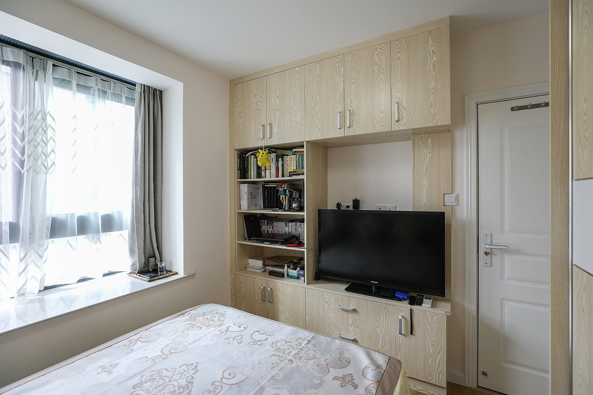 卧室的设计也充分利用了整个空间，大衣橱以及床对面的多功能书柜，增加了大部分的储物功能，也更加的实用。 
