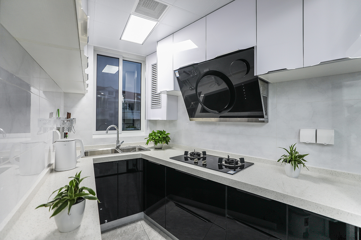 U型的厨房设计使得烹饪时的操作更为便利，黑色的下柜和白色上柜形成鲜明的对比，多出了一份设计感。
