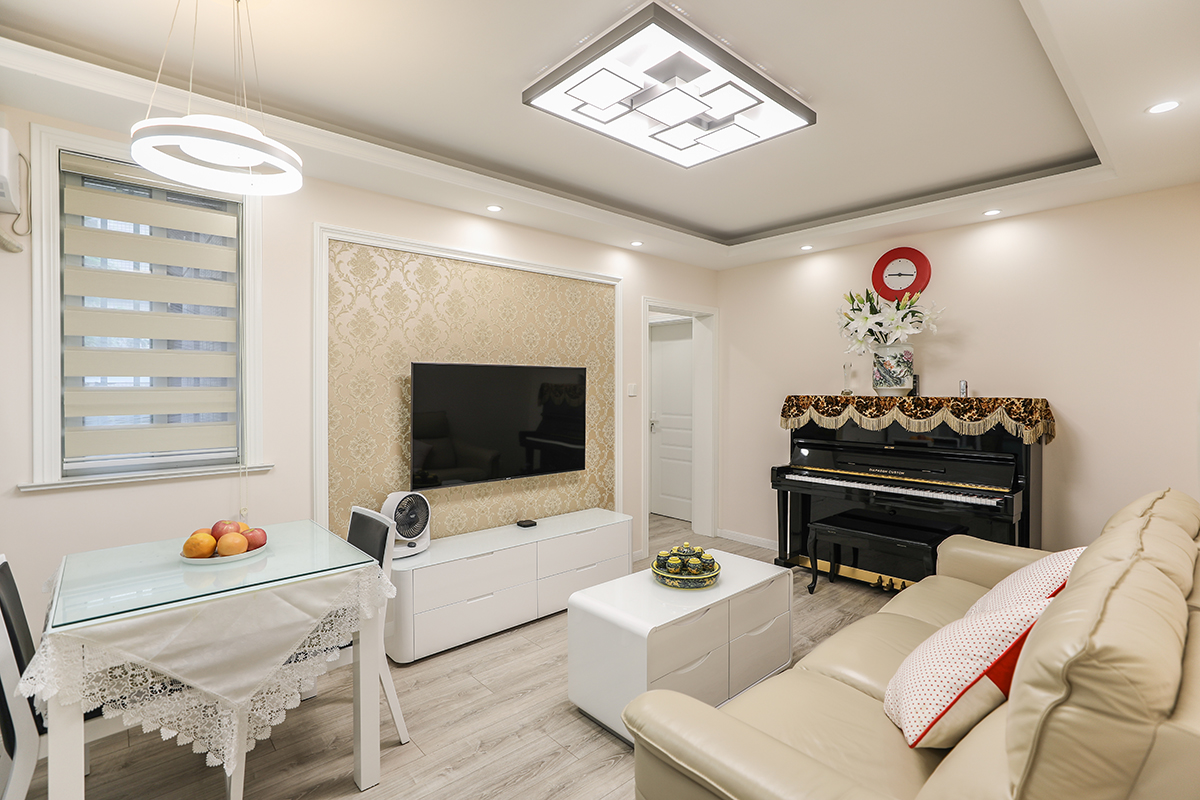 米黄色电视背景墙和白色电视柜完美的结合，强化了空间利用率，让整个客厅更明朗开阔，配上典雅的钢琴，展现了主人优雅的内涵和品位。
