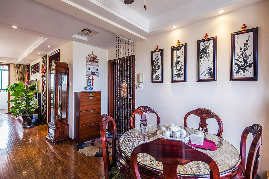 玄关处，饰以精巧的珠帘和雅致的挂画，把人带入一种中式文化元素的家庭
